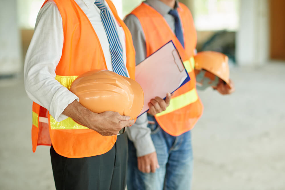 Professionnels portant des équipements de sécurité discutant des conditions de travail et des obligations