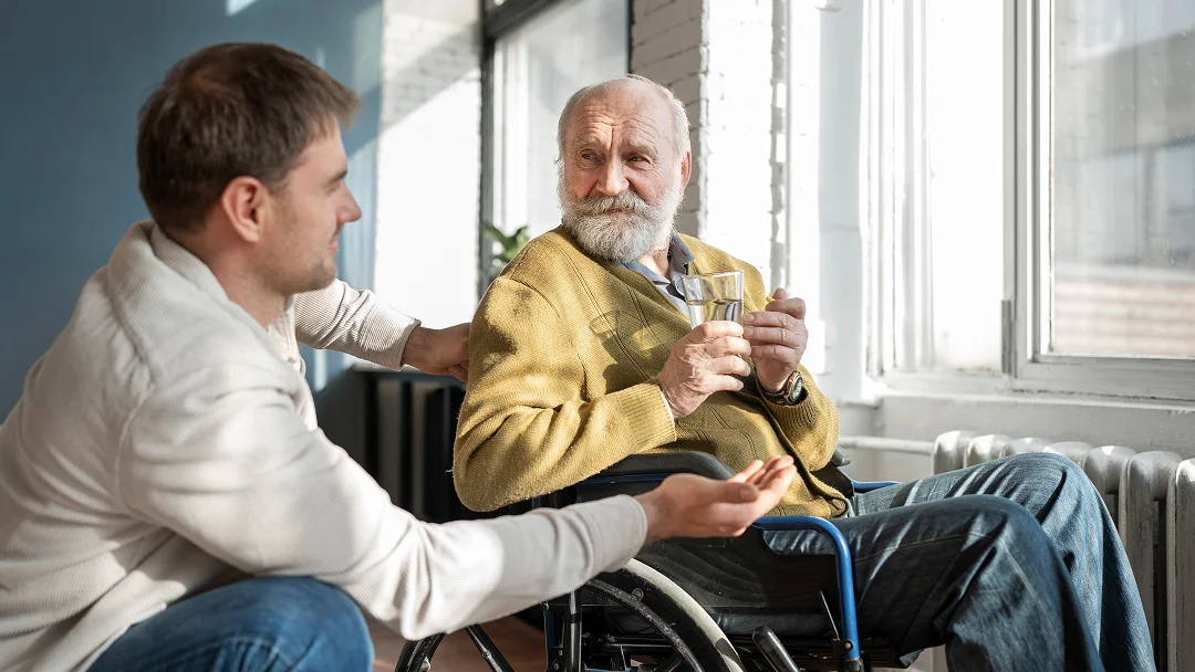 Un homme en fauteuil roulant discute avec un autre homme, abordant le thème de travailler avec une rente d'invalidité.